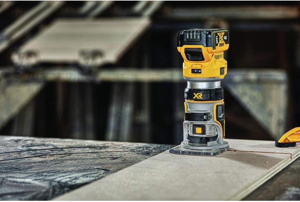 The DeWalt 20V MAX XR router sitting on a plywood workbench in a workshop