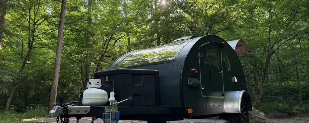 A teardrop camper parked at a creek-side campsite at Elkmont Campground in the Great Smoky Mountains