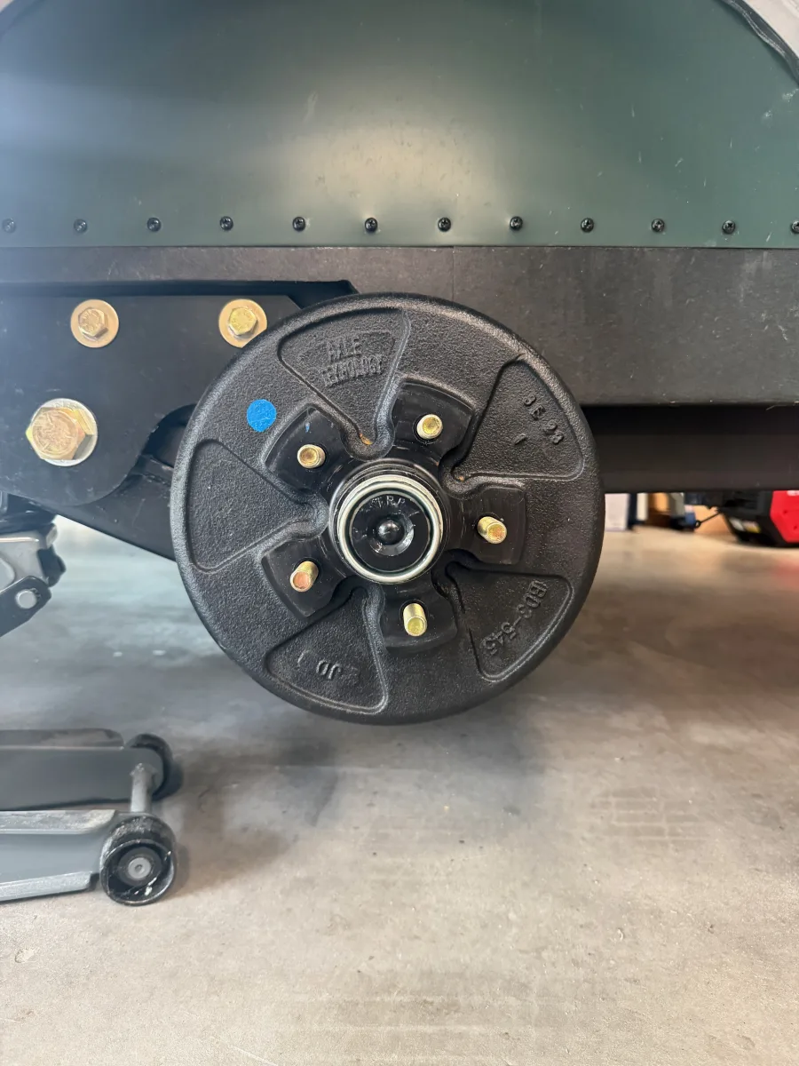 Bare trailer hub and brake drum with exposed wheel studs, before the wheel spacer is installed