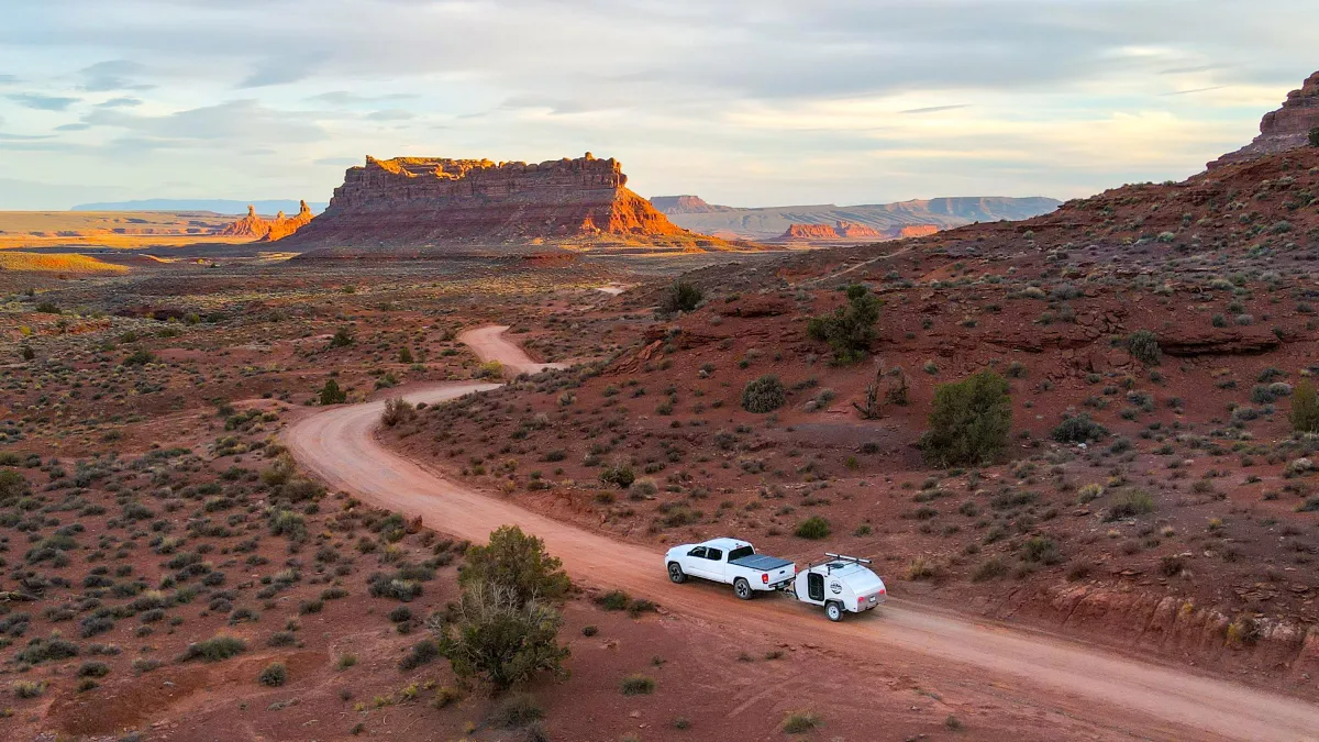 A teardrop camper built from The Builders Network plans, towed down a desert road