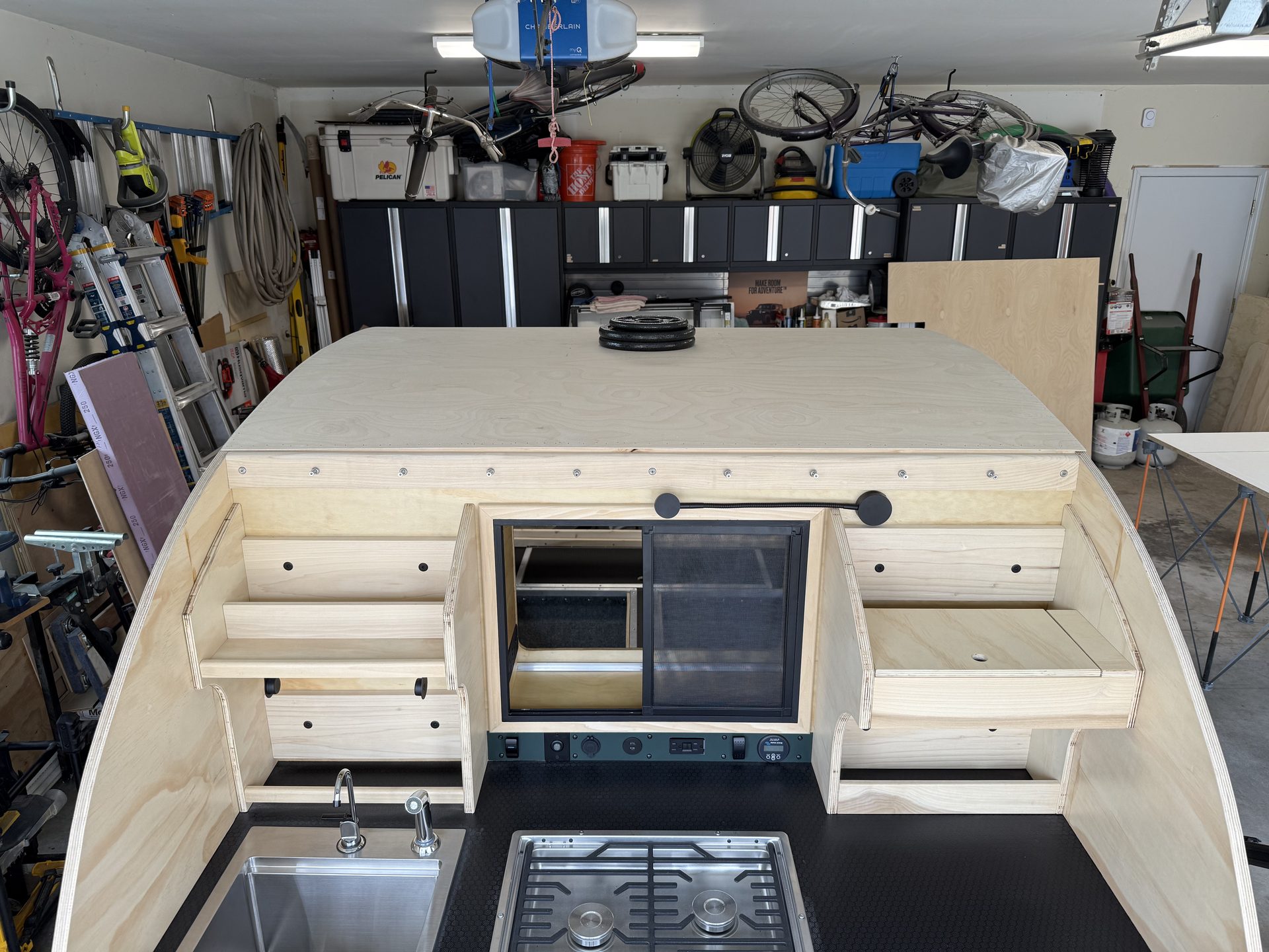 A quarter-inch Baltic birch roof skin installed over the insulated roof of a teardrop camper, viewed from above the galley